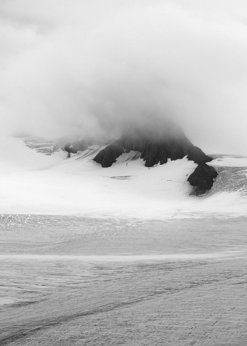 Misty Alaskan icefield mostly obscured by rolling clouds