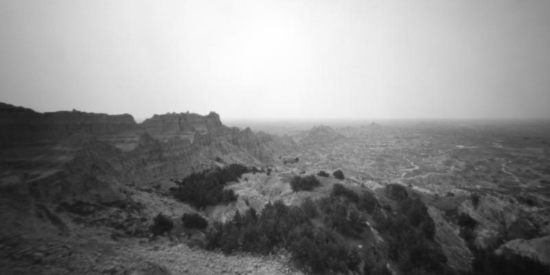 Black and white pinhole image of badlands formations stretching into the distance